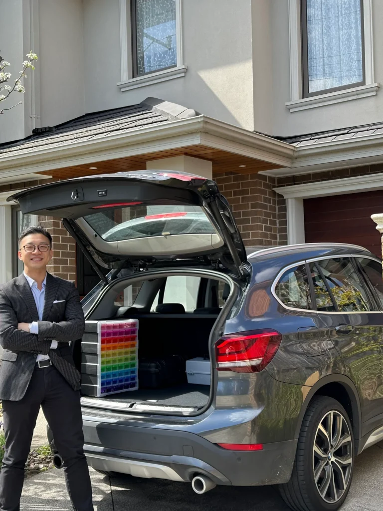 director of neurohearing standing in front of his car with the trunk open